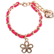 Dettaglio del bracciale intrecciato oro e rosa con ciondoli a cuore e fiore