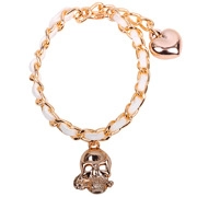 Dettaglio di un bracciale a catena dorata con ciondoli a teschio, cuore e cinturino bianco