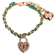 Dettaglio del bracciale a catena dorata e pelle verde con ciondoli a cuore e lucchetto