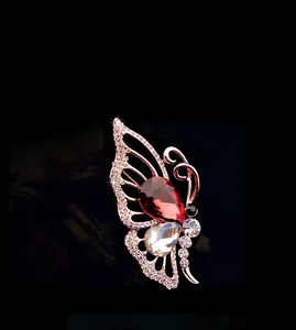 Détail de la broche papillon avec cristal rouge en forme de goutte et plaquage or rose