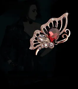 Détail de la broche papillon en or rose sertie de cristaux rouges et blancs