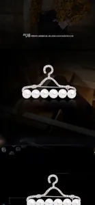Détail de broche en cintre argenté avec six perles blanches et strass posés à la main