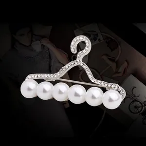 Broche élégante en forme de cintre argenté avec cristaux étincelants et perles blanches