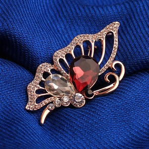 Broche papillon élégante en or rose avec pierres rouges et cristaux étincelants