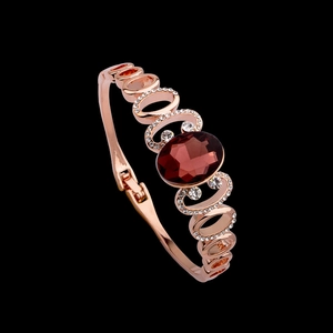Elegant rose gold open bangle featuring a large oval red crystal and sparkling zircon accents