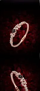 Dettaglio di bracciale in oro rosa con lettere LOVE e trifoglio nero con zirconi cubici