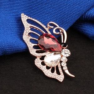 Broche papillon or rose avec pierre rouge en forme de goutte et strass scintillants