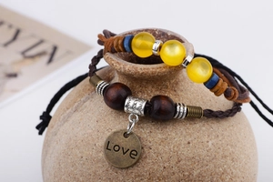 Détail de bracelets bohèmes deux pièces avec perles en bois et pendentif Love en métal gravé
