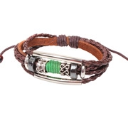 Détail du bracelet en cuir tressé avec cordon vert et ornements en métal argenté