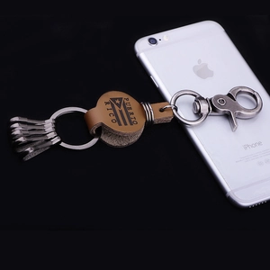 Porte-clés vintage en cuir Porto Rico avec crochets en métal à côté d'un smartphone