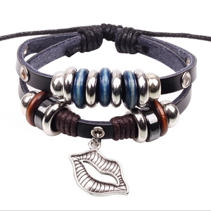 Détail de bracelet multicouche en cuir avec perles bleues et pendentif lèvres argenté