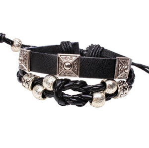 Détail de bracelets en cuir noir vintage avec ornements en métal argenté et corde tressée