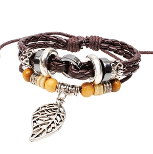 Gros plan d'un bracelet en cuir tressé rétro avec perles en bois et pendentif feuille