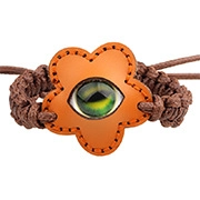 Détail du bracelet tissé en cuir orange avec fleur et perle d'œil de verre verte
