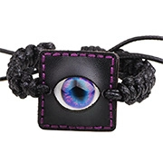 Détail d'un bracelet en cuir tressé punk avec un charme d'oeil bleu-violet réaliste