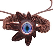 Détail d'un bracelet en cuir tressé avec un écusson en forme de feuille et un œil bleu