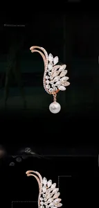 Dettaglio macro della spilla piuma oro rosa con cristalli e pendente perla a goccia