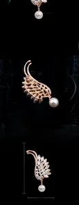 Dettaglio spilla piuma oro rosa con cristalli e pendente di perla, altezza di 7,7 cm