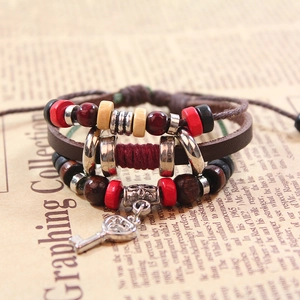 Macro shot of multilayer bohemian leather bracelet with wooden beads and key charm
