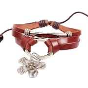 Detail of vintage multilayer leather bracelet with silver flower charm and studs