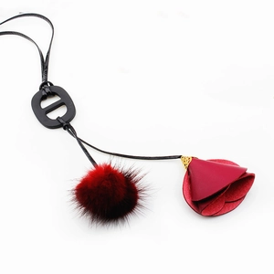 Sautoir rouge élégant avec pompon en fourrure et pendentif fleur en cuir chic
