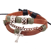 Close-up of multilayer leather bracelet featuring a cross pendant and metallic charms