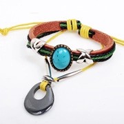 Macro detail of multilayer leather bracelet featuring a blue turquoise stone and teardrop charm