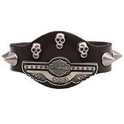 Close-up of wide leather bracelet with metal skulls, spikes and a center wing emblem