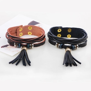Bohemian multilayer leather bracelets with metal beads and tassel charms on white surface