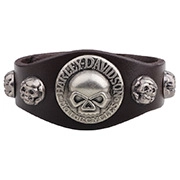 Detailed view of punk leather bracelet featuring skull rivets and a round metal centerpiece