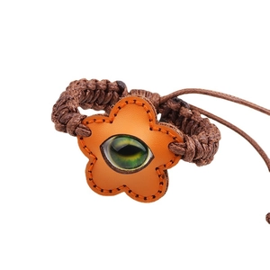 Ethnic woven rope bracelet with leather flower charm and central glowing glass eye bead