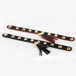 Punk style leather bracelets with metallic gold studs and fringe tassels in black and brown
