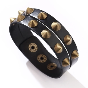 Détail du bracelet en cuir noir double couche avec clous punk coniques bronze rétro