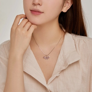 Close-up of S925 sterling silver butterfly pendant with pink cubic zirconia on collarbone