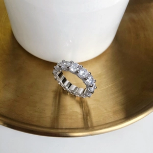 Gros plan d'une bague d'éternité en argent S925 sertie de cristaux pavés sur plateau doré