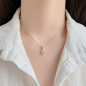 Macro detail of S925 sterling silver necklace with zircon pendant on a female model