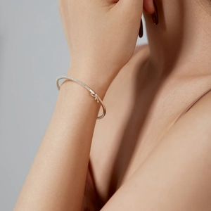 Elegant S925 sterling silver open bangle featuring a row of pave diamonds on model wrist