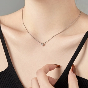 Close-up of minimalist S925 silver necklace with 4mm round zircon pendant on neck