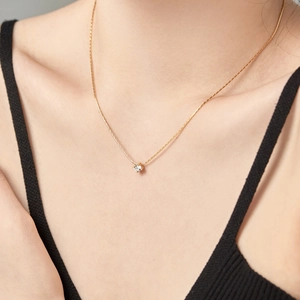 Detail of 4mm zircon pendant on a gold S925 sterling silver chain worn by a model