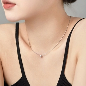 Detail of S925 sterling silver necklace with 4mm zircon pendant on a female model