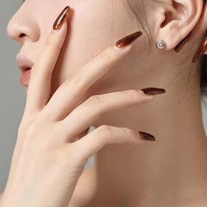 Close-up of minimalist S925 sterling silver stud earring with clear zircon inlay on ear