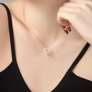 Close-up of a double-layered heart pendant necklace with zircon pavé on a model