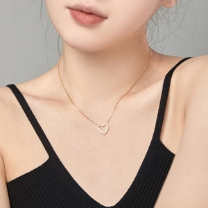 Close-up of elegant double heart pendant necklace with zircon inlay on model's neck