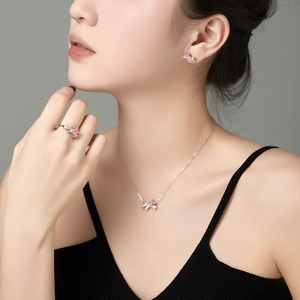 Detailaufnahme des S925 Silber-Schmucksets mit rosa Herzsteinen und Schleifen-Motiv