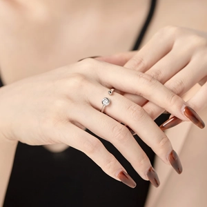 Elegant adjustable silver ring on hand featuring a single round cubic zirconia stone