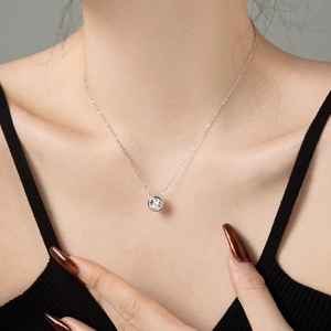 Model wearing a delicate S925 sterling silver necklace with a round cubic zirconia pendant