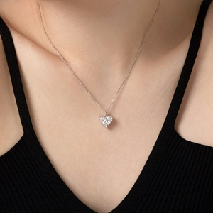 Close-up of S925 sterling silver heart necklace with sparkling zircon on a female model