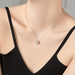 Close-up of minimalist S925 sterling silver necklace with a sparkling solitaire zircon