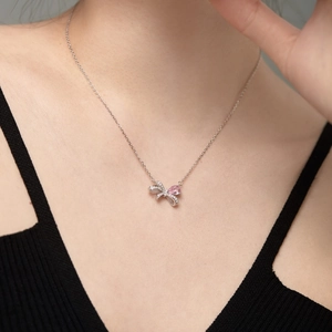Detailansicht der silbernen Schleifenkette mit rosa Herzstein und Pavé-Fassung