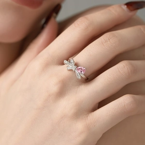 Dettaglio di un anello in argento S925 a forma di fiocco con una gemma rosa a forma di pera